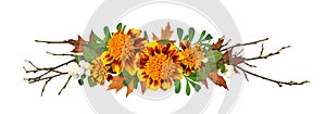 Orange and red marigold flowers, autumn oak leaves and dry twigs in a fall arrangement isolated