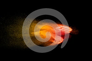 Orange red  powder explosion on black background.Orange red color dust splash clouds