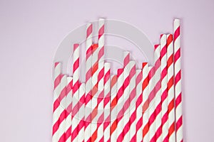 Orange and red straws on the pink background