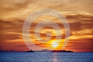 Orange and red sunset sky with ocean and island photo