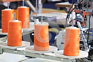 Orange reels of threads industry background, Spools of colored cotton thread, ordered composition