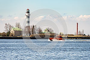 Orange rescue tug entering port of Riga town in Latvia