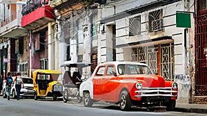 Orange retro car taxi and people passers-by in the old center of Havana.