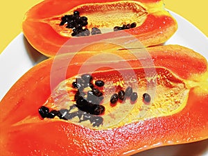 Orange Ripe Papaya Cut in Half Isolated on Yellow Background