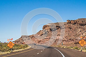 Orange Road work ahead caution signs on empty highway in southwest