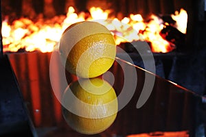 Orange rolls on the mirror in the furnace furnace fire burns