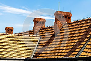 Orange roof and chimneys against the background of blue sky