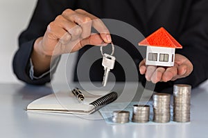 Orange roof house in the hands of businessmen, home insurance concept Property protection. Businessmen protect orange houses.