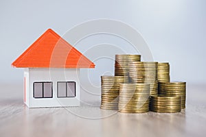 Orange roof houses and coins heap, saving money for new home purchases or loans to plan your real estate investment business. Home
