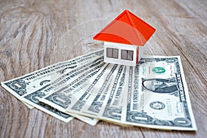 Orange roof houses placed on banknotes, real estate investment ideas, home savings and purchases, mortgages and loans, banking,