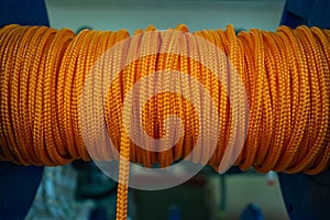 The orange rope is reeled up on the coil in shop. A saving or safety rope for climbers