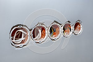 Orange, round installation box mounted in a white wall with an extension installed.