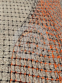 Orange Safety Barrier Mesh and Grid Shadow on Concrete