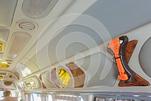 Orange safety glass hammer mounting near the window glass and curtain on the van for use to break the glass