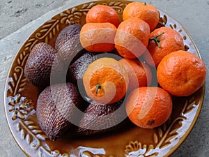 Orange and salak on plate outdoor