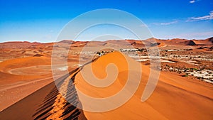 Orange sand dunes under blue sky in dry desert in Namibia, Southern Africa