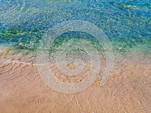 Orange sands and crystal clear blue water - empty beach in Crete, Greece