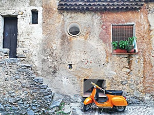 Orange scooter parked at the historic center of S. Giovanni in Piro in Italy