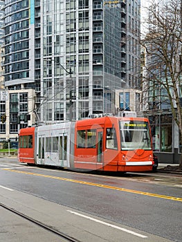 Orange Seattle Streetcar on damp Seattle street in winter