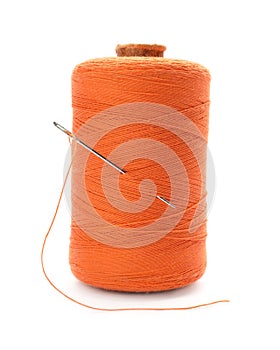 Orange sewing thread with needle on white background