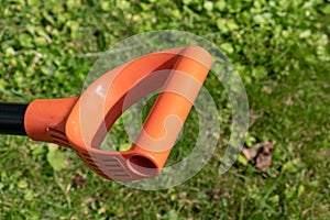 Orange shovel handle in garden close up, gardening in spring and summer concept