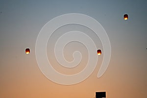 orange sky lantern floating in the middle of grey sky on the festival of independence day makar sankranti uttarayan