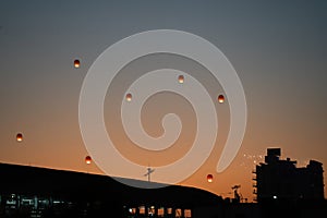 orange sky lantern floating in the middle of grey sky on the festival of independence day makar sankranti uttarayan with