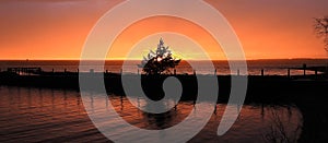 Vibrant orange sunset sky after lake storm panoramic banner