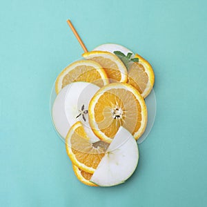 Orange sliced orange and apple fruits, orange juice with cockail straw on blue background. top view. Square iamge