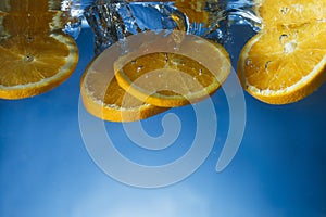 Orange slices dropped in crystal clear water