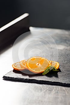 Orange slices with meant at kitchen table. Closeup fresh orange at kitchen.