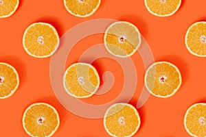 Orange slices pattern on bright orange background. Minimal flat lay concept