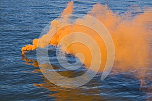 Orange smoke on water