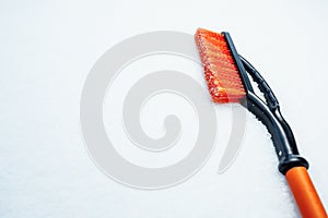 Orange snow brush for car, snowflakes background