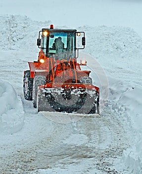 Orange snow plow clears the streets