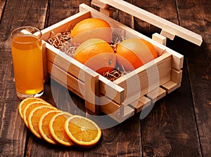 Orange soda and oranges in wooden box