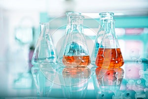 Orange solution in glass flask at chemical green science and technology research laboratory background