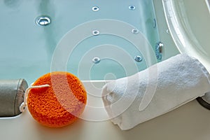 Orange sponge and towel on the hot tub