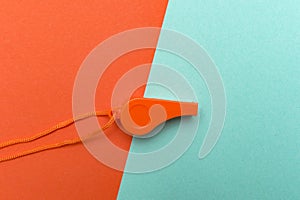 Orange sports whistle on orange background.Concept- sport compet