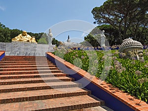 Orange stairs and many various large buddhas. Quinta dos Loridos, Portugal.