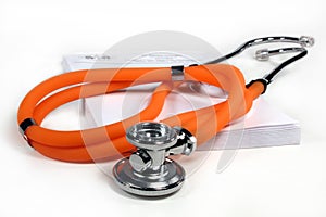 Orange stethoscope on prescription pad