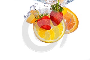 Orange and strawberries falling into water splash