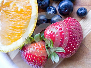 Orange Strawberry Blueberry Fruits on Wooden Cutting Board