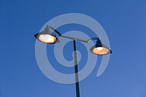 Orange streetlamps against blue sky