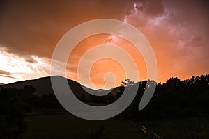 Orange sunset behind hills in Lika