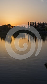 Orange sunset near the calm water of the lake