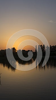 Orange sunset near the calm water of the lake