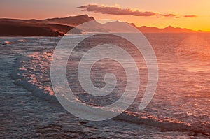 Orange sunset. ocean landscape. Rocks and wave of ocean