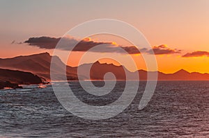 Orange sunset. ocean landscape. Rocks and wave of ocean