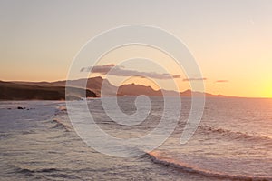 Orange sunset. ocean landscape. Rocks and wave of ocean